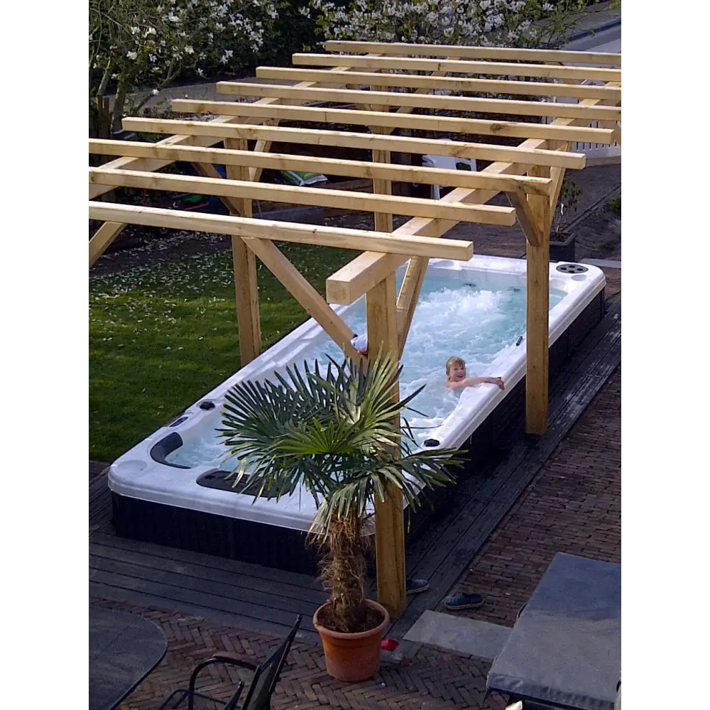 Vit och svart PassionSpa Aquatic 2 Swim Spa med bubblande vatten under pergola